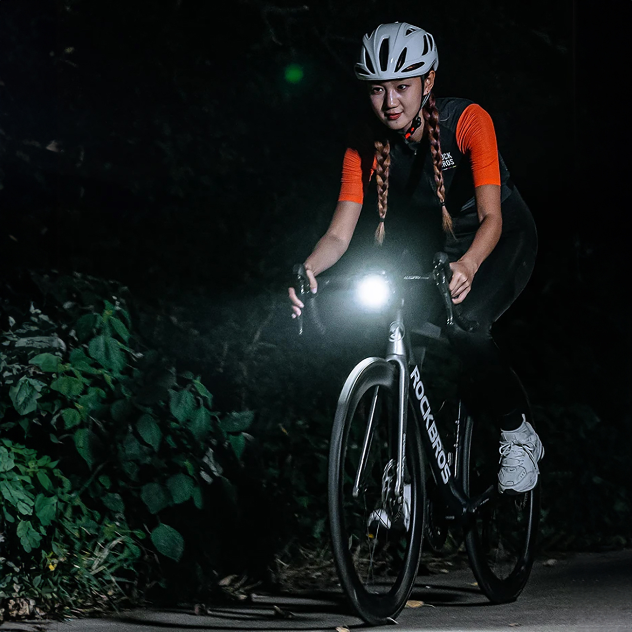 Woman cycling at night with a Rockbros RHL1500 bicycle light