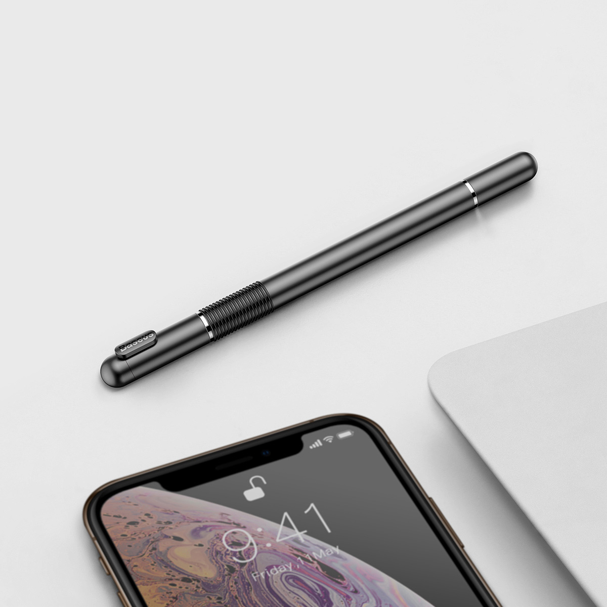 The phone lying on the desk next to the Baseus Golden Cudgel double-sided stylus