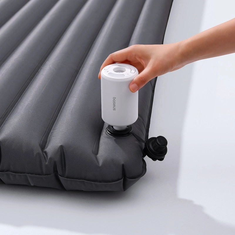 A person inflates the mattress with a portable Baseus PocketGo Pro tourist pump