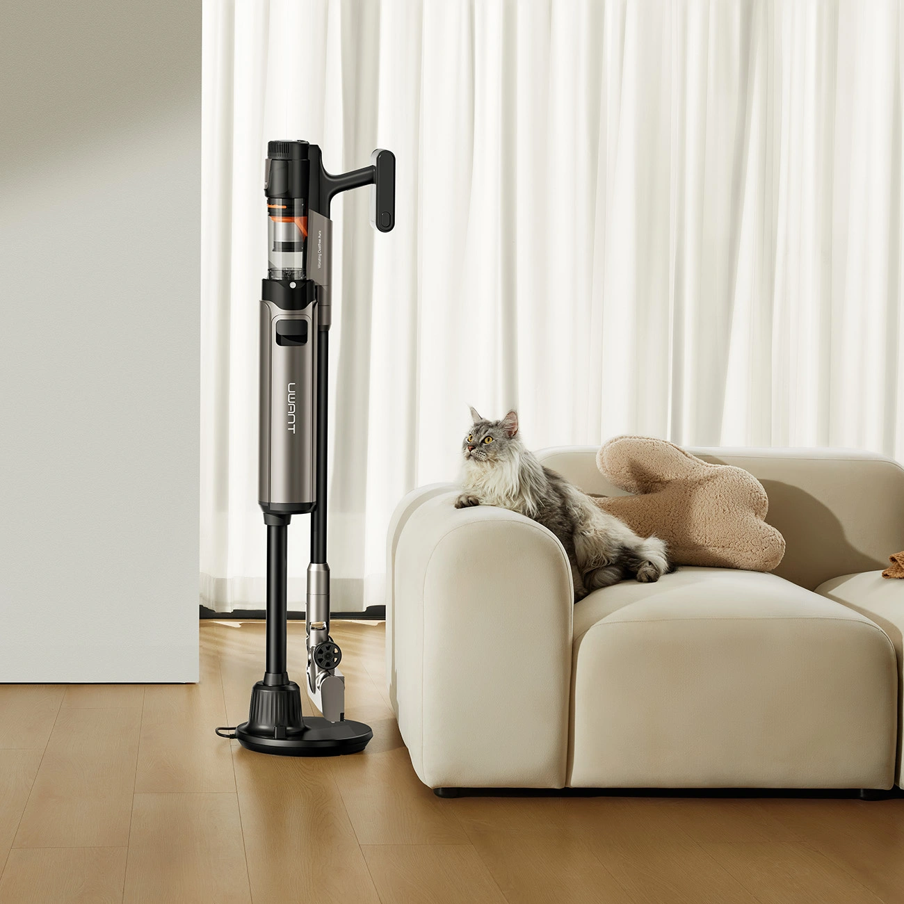 A cat lying on the couch looks at the UWANT V600 vacuum cleaner standing next to it in the docking station.