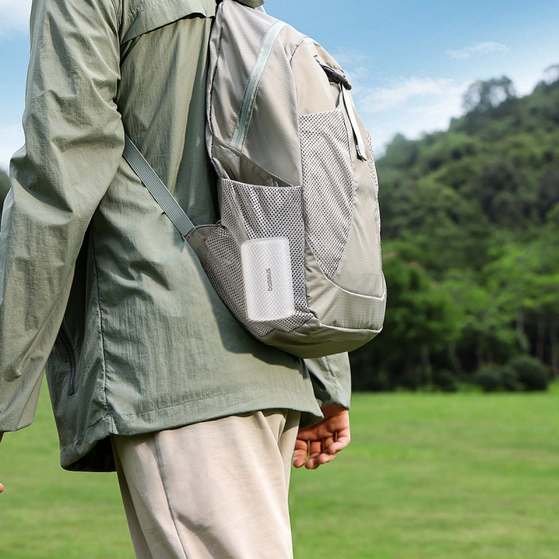 A person is carrying a Baseus PocketGo Pro portable tourist pump in the side pocket of the backpack