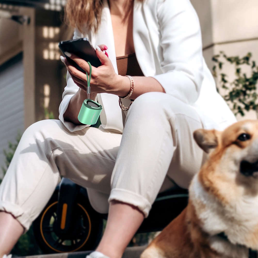 A woman talking on the phone using a Tronsmart Mini speaker.