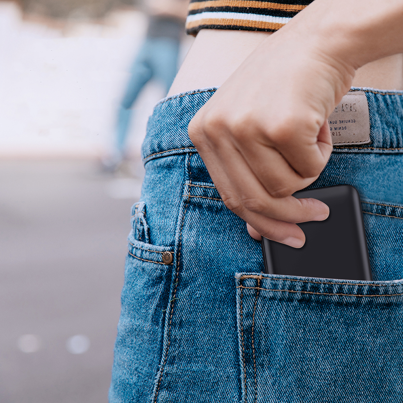 Woman putting Choetech B654 power bank into her back pocket