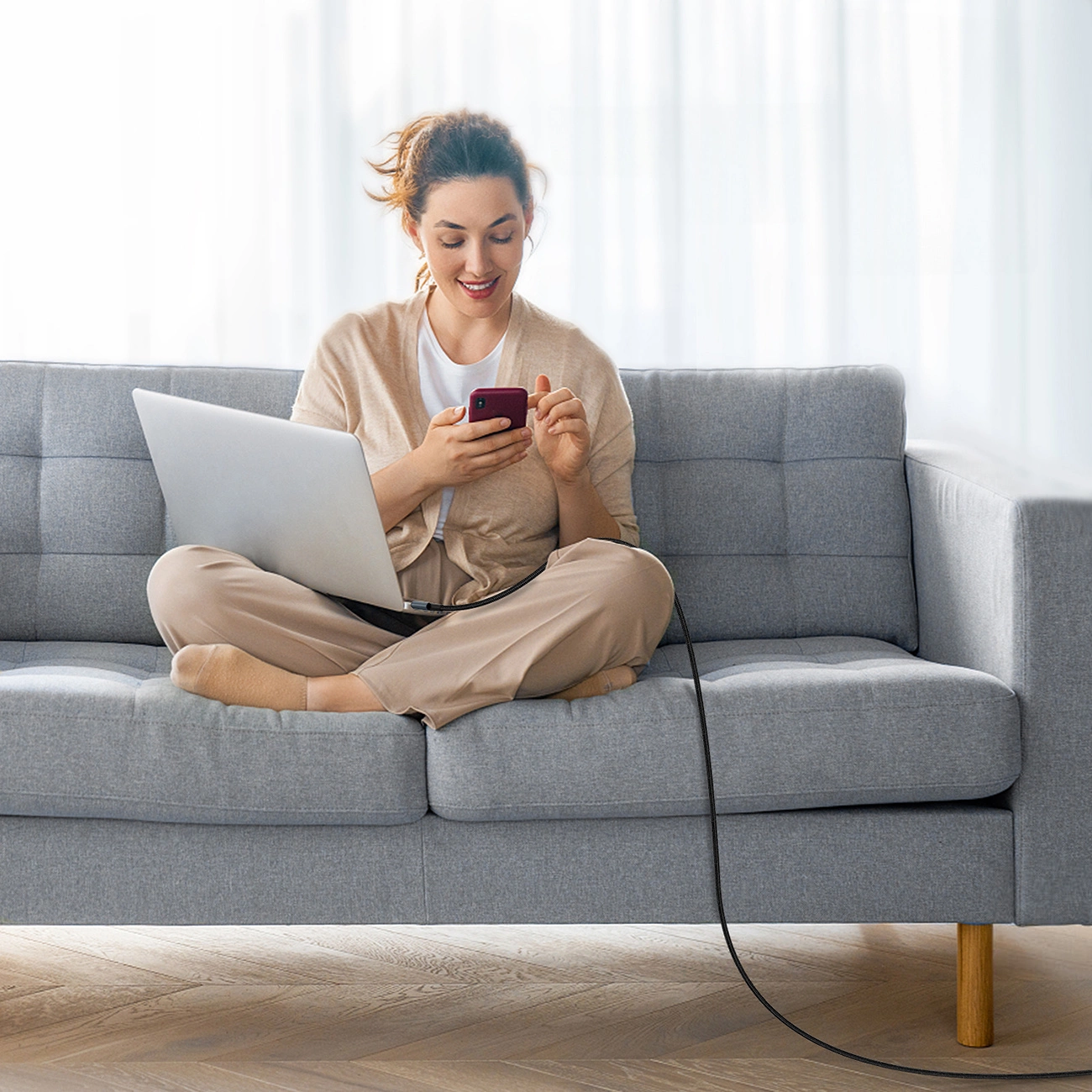 A woman charges her computer with the Choetech XCC-1014 cable