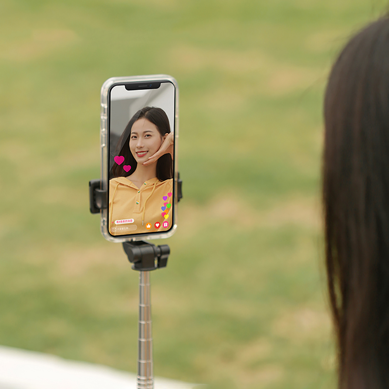 A woman making a live video with the WHS1Y selfie stick