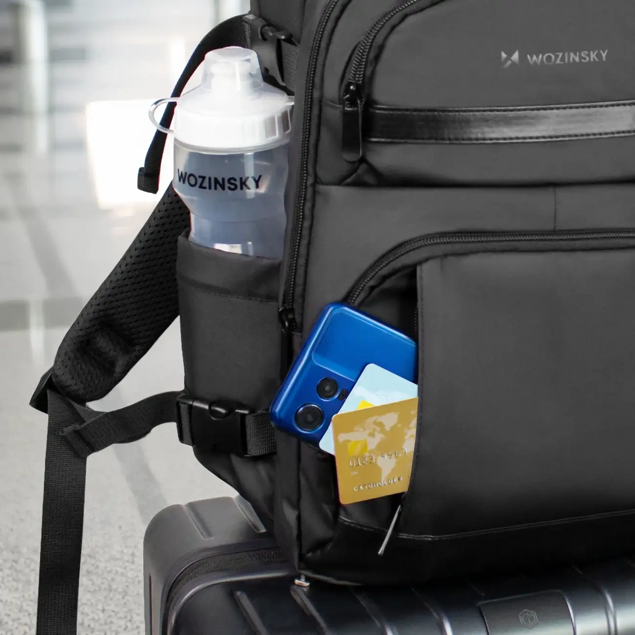 The pockets of the Wozinsky WPW-20L backpack are filled with credit cards, a cell phone and a water bottle.