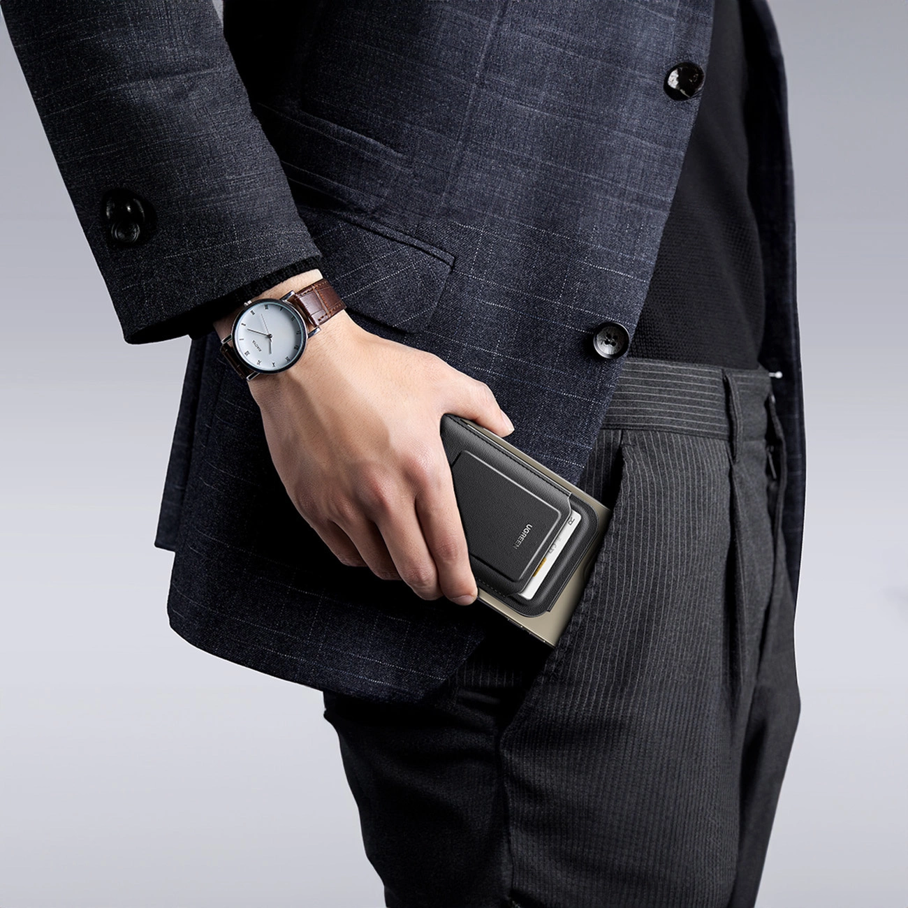 A man puts the Ugreen Magnetic Wallet 45165 into his pocket