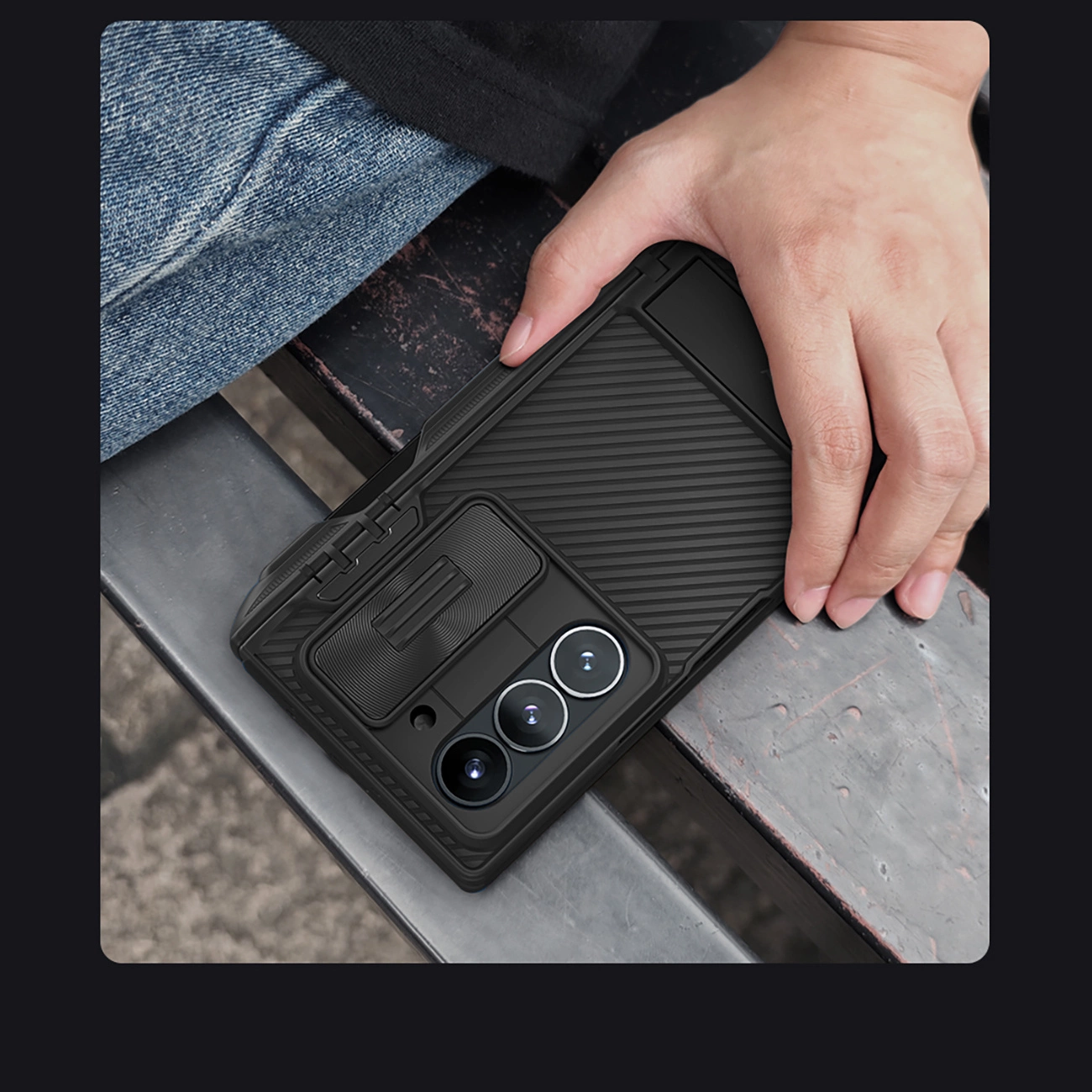 A hand holding a phone in the Nillkin CamShield Fold Case