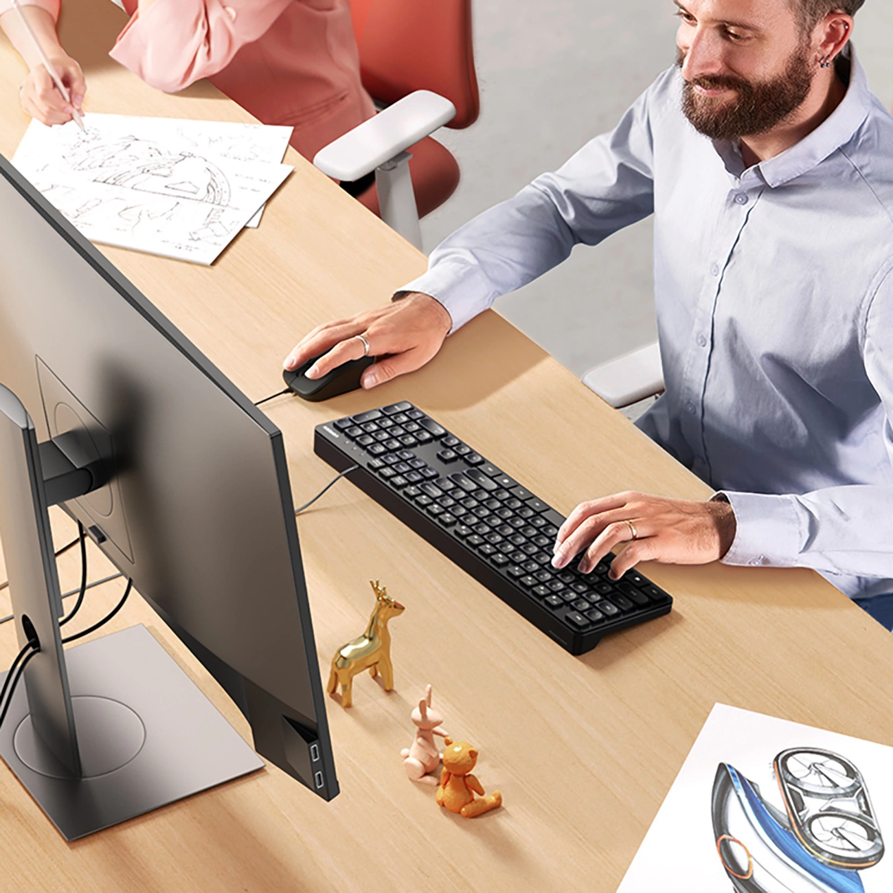 A man uses a computer using the Ugreen KU004 wired keyboard