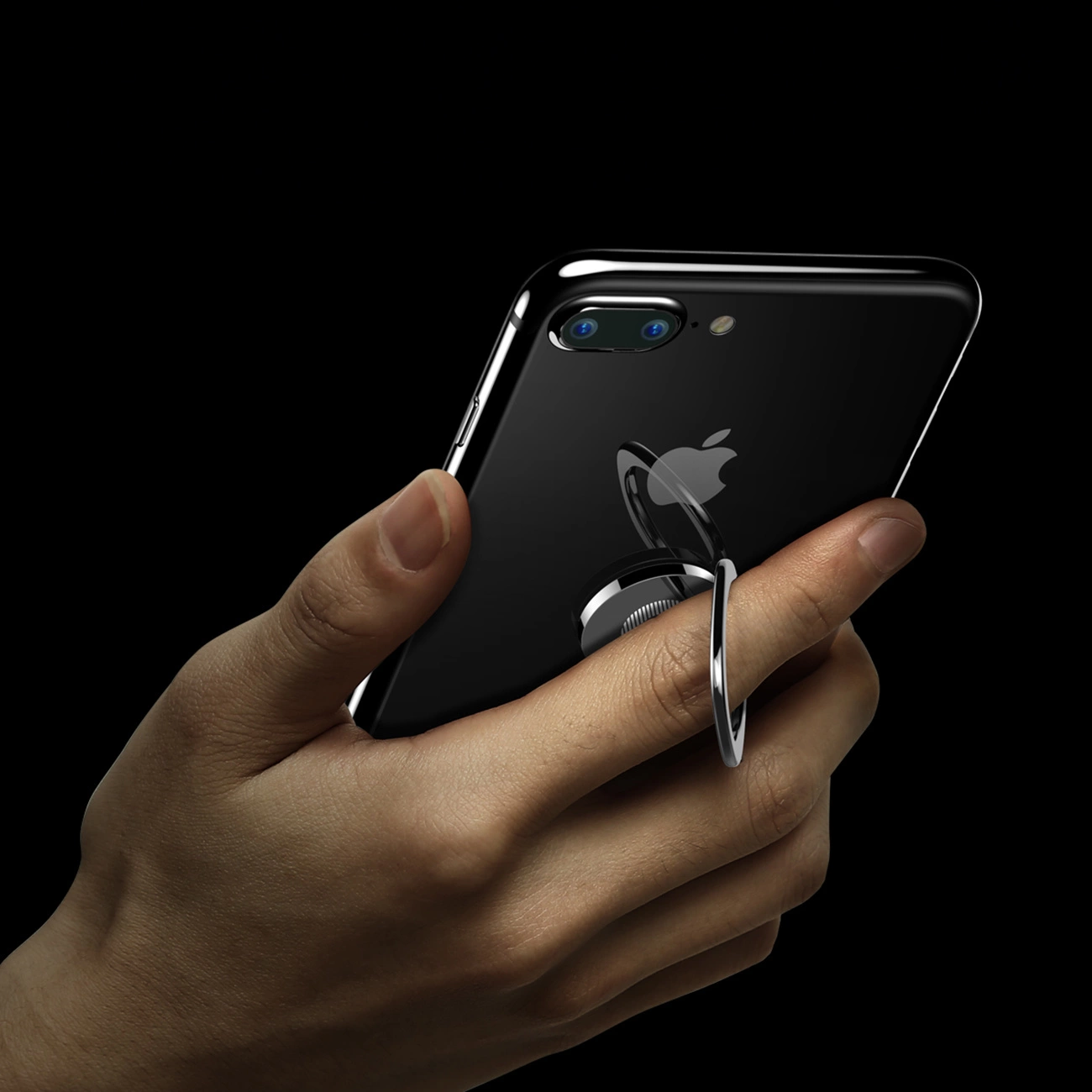 Ręka trzymająca telefon z przymocowanym uchwytem Baseus Privity Ring nałożonym na palec wskazujący