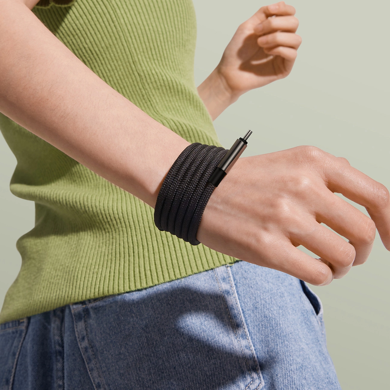 The woman has a Baseus Tungsten Gold Magnetic cable tied around her wrist