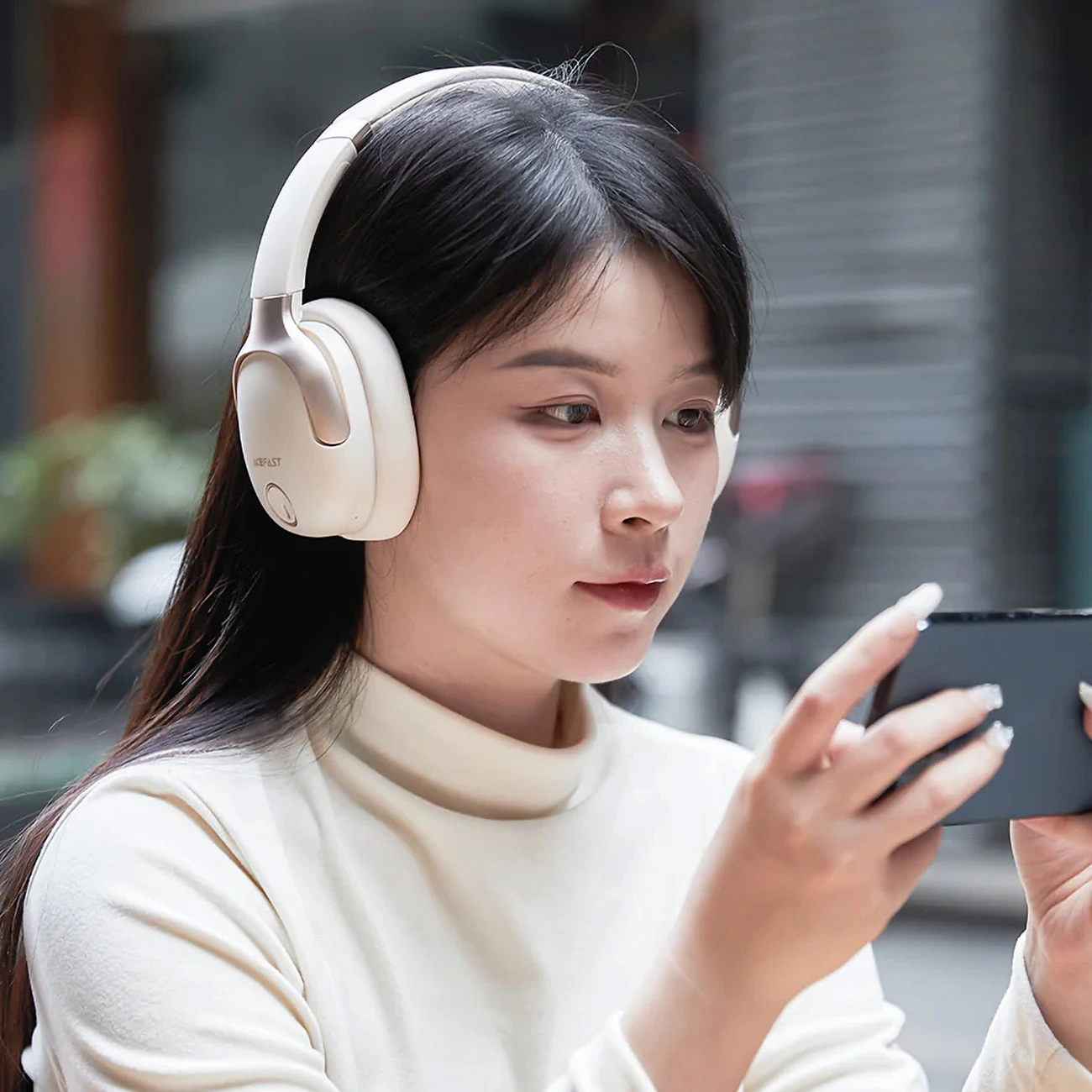 Woman watching a movie on her phone with Acefast H2 headphones