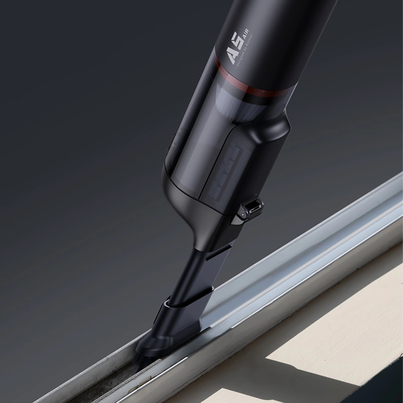 A person cleans the window frame with a Baseus A5 Air car vacuum cleaner with a special tip