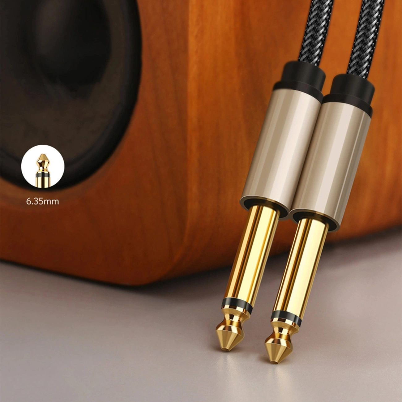 Close-up of the gold-plated ends of the Ugreen AV128 cable leaning against the speaker