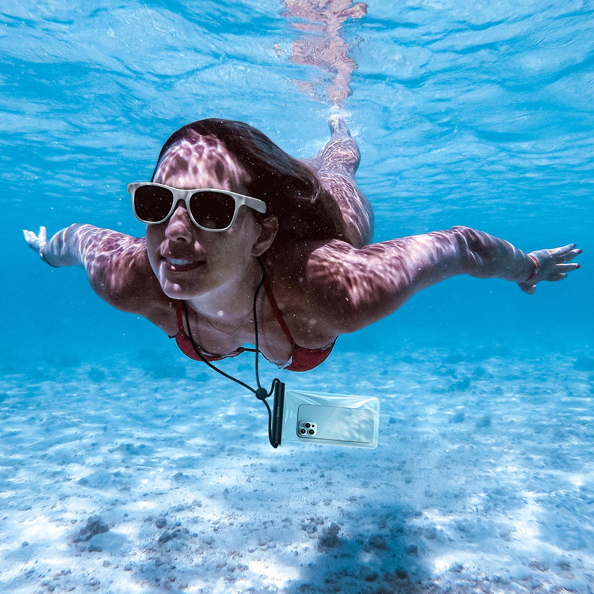 Woman diving with the Baseus AquaGlide BS-PC030 waterproof cover