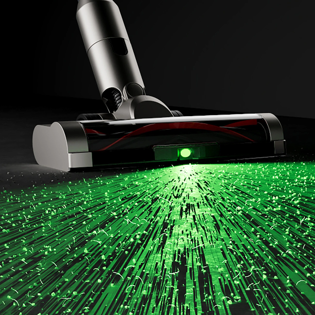 A close-up of a working vacuum cleaner brush with a green LED light visible, and particles and their stretched shadows clearly visible on the floor in front of it.