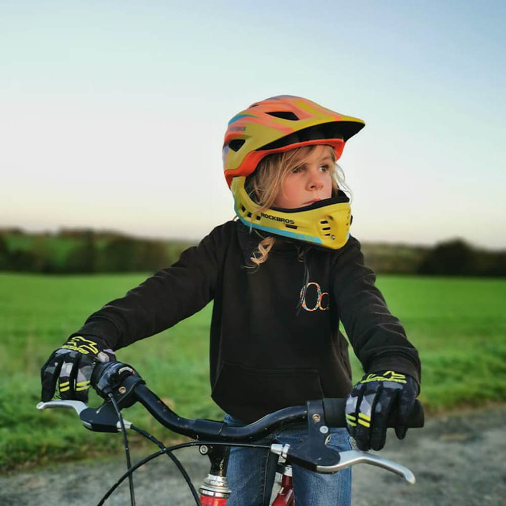 A boy in a Rockbros TT-32SOYB-S bicycle helmet with a detachable chinbar