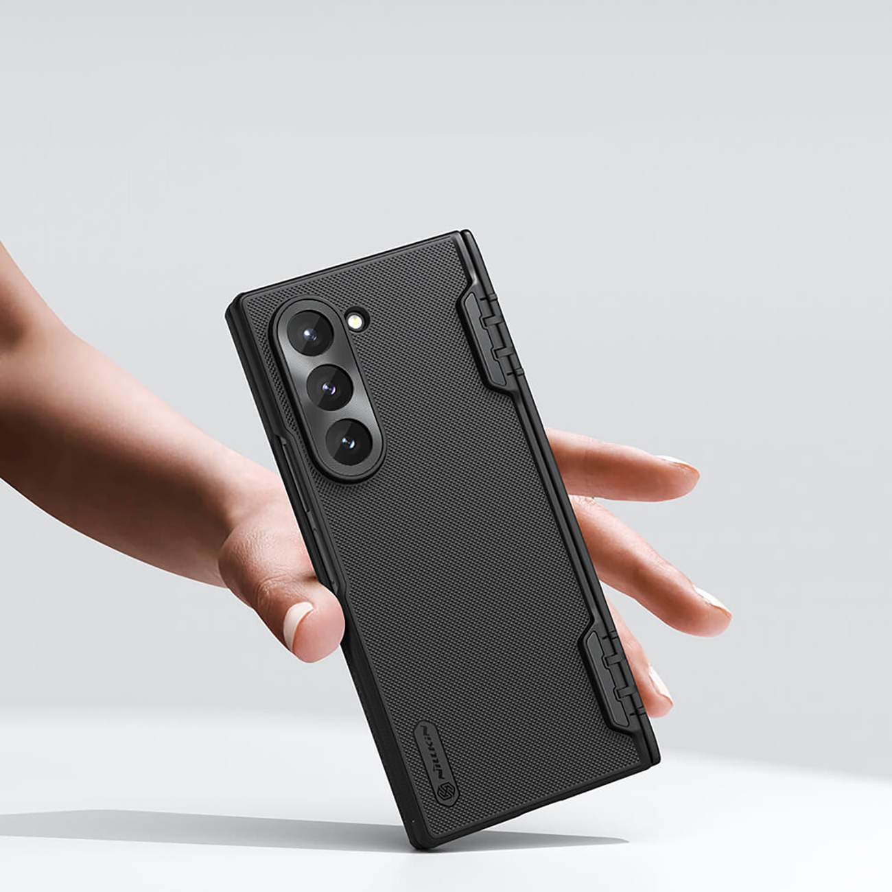 A hand holding a phone in the Nillkin Super Frosted Shield Pro Magnetic Case