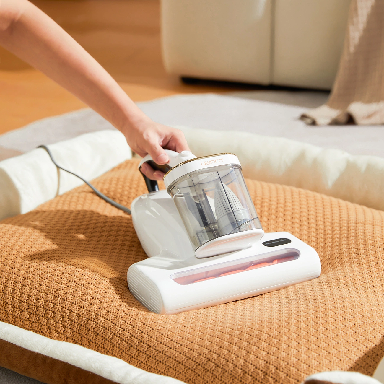 Photo showing the UWANT M600 vacuum cleaner in operation on an orange dog bed.