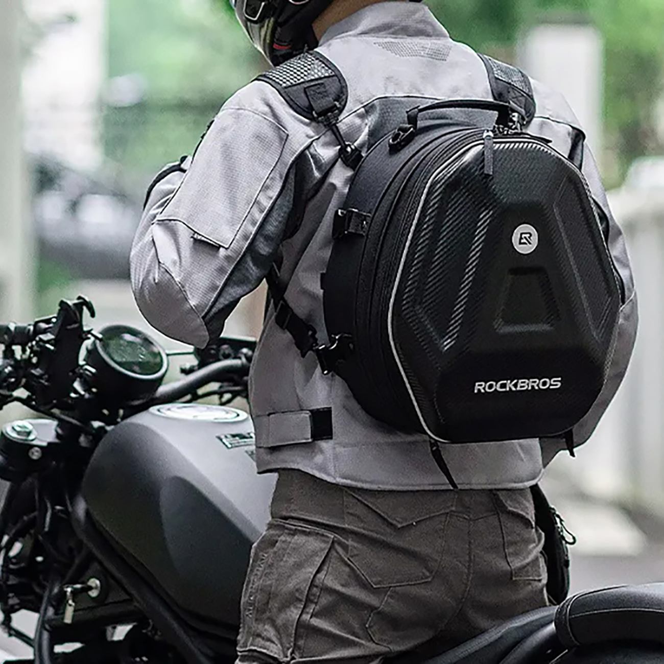 A man standing next to a motorcycle wearing a helmet and wearing a Rockbros backpack 30140026001